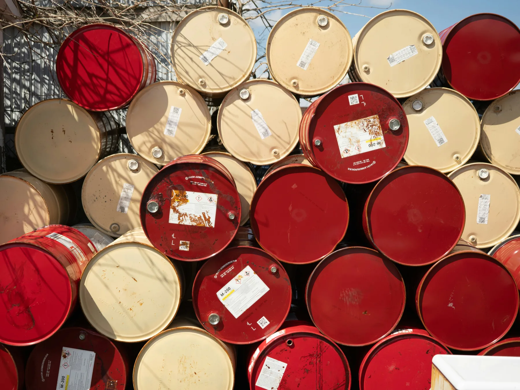 Stacked red and cream chemical drums with GHS labels